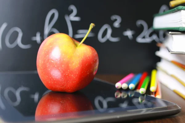 Manzana roja en el cuaderno con pila de libros —  Fotos de Stock