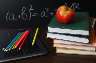 üstünde defter kitap yığını ile kırmızı elma