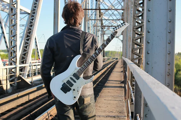 Homem com uma guitarra em uma estrada de ferro — Fotografia de Stock