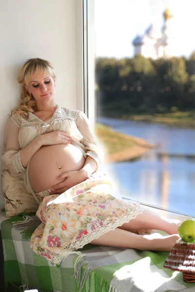 Barriga mulher grávida perto da janela — Fotografia de Stock