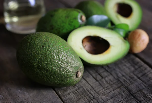 Avocado en olieverf op houten achtergrond — Stockfoto