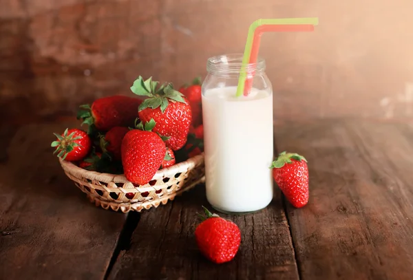 Mesa de madera con fresas y leche en un vaso —  Fotos de Stock