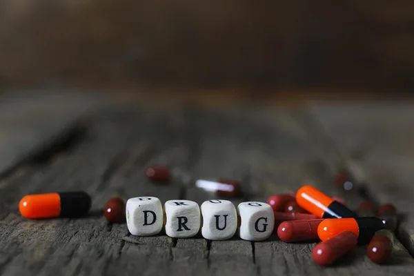 Píldora de drogas en la adicción concepto de mesa de madera — Foto de Stock