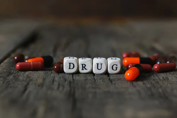 Лекарство таблетки на деревянный стол концепция наркомании — стоковое фото