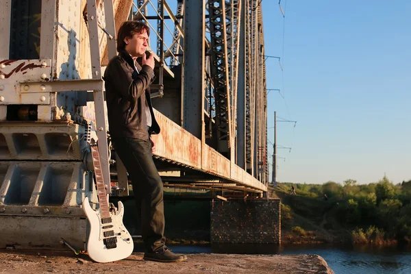 Homem com uma guitarra em uma estrada de ferro — Fotografia de Stock