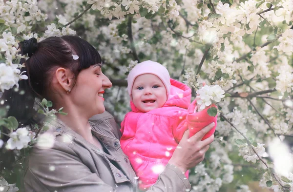 Мама з дитиною в яблучному саду — стокове фото