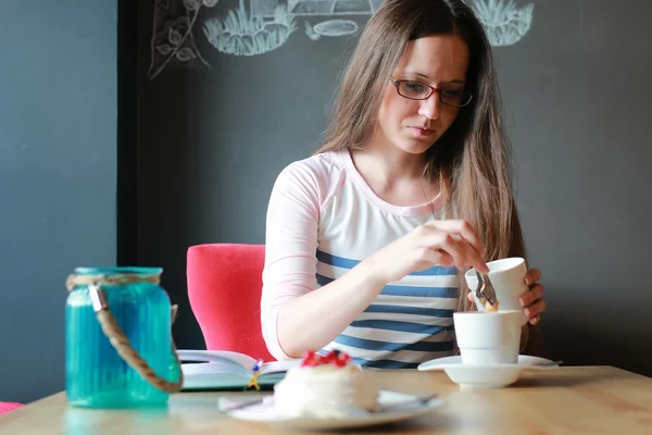 Flicka i ett café för en kopp kaffe med anteckningsboken — Stockfoto