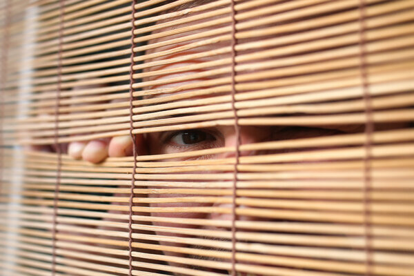 eyes looking through the blinds