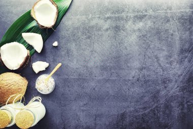 Hindistan cevizi koyu taş bir masada. Hindistan cevizi yağı ve kaşık.