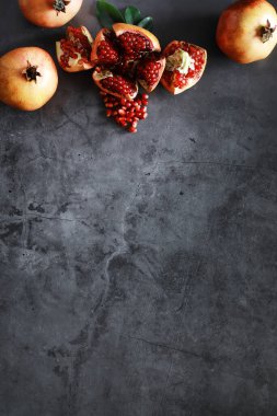 Olgunlaşmış kırmızı nar. Masanın üzerinde olgun nar taneleri var. Nar suyu..