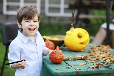 Sonbahar gelenekleri ve Cadılar Bayramı hazırlıkları. Doğada bir ev, masada balkabağından yapılmış bir lamba kesilir..