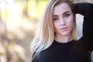 Sonbahar parkında yürüyüş yapan genç ve güzel bir kız. Şehir parkında yapraklar dökülüyor. Ekim.