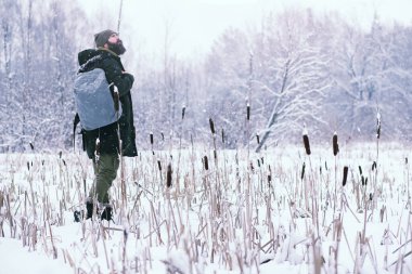 Kış ormanlarında sakallı adam. Çekici, mutlu, sakallı genç bir adam parkta yürüyor..