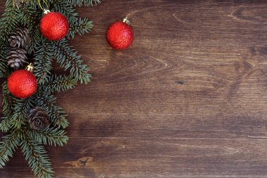 Yeni yıl geçmişi. Ahşap bir masada ladin dalları. Yeni yıl ağacı için süsler. Noel kutlaması