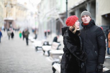 Genç bir çift kış şehrinde yürüyor.