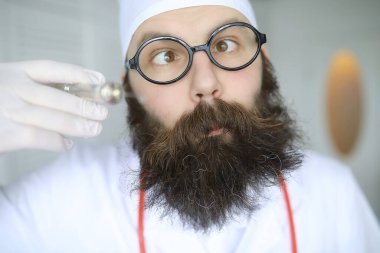 Doktor deli. Çılgın sakallı bilim adamı bilimsel bir laboratuvarda deneyler yapıyor. Şırınga ve steteskop kullanarak araştırma yapar.