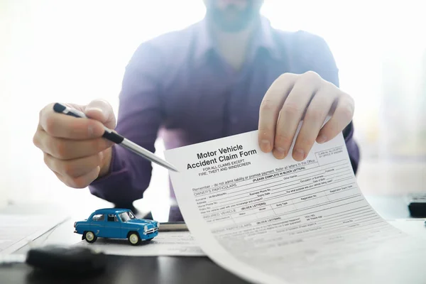 The insurance agent signs a document. Car insurance policy. Auto insurance policy. Forms registration of the contract.