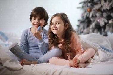 Çocuklu bir aile Noel tatilinde yorganın altında eğleniyor..