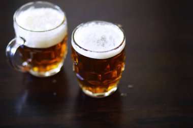 Tahta bir masada bir bardak taze bira. Bira bardağı taş masada. Üst görünüm kopyalama alanı