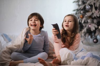 Çocuklu bir aile Noel tatilinde yorganın altında eğleniyor..