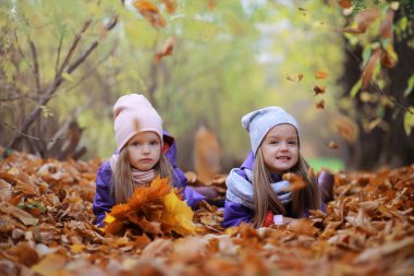 Genç bir aile güneşli bir günde sonbahar parkında yürüyüş yapıyor. Birlikte olmanın mutluluğu..
