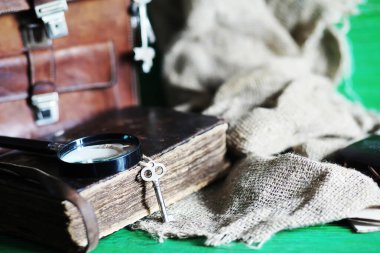 Kahverengi bir gezgin ahşap masa arka planında büyüteç olan eski deri çanta..