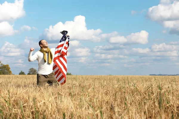 Man waving American flag standing in farm agricultural field , holidays, patriotism, pride, freedom, political parties, immigrant