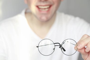 Kötü görüş kavramı. Kontak lens ve gözlüğü elinizde tutun. Reklam gözlükleri ve lensler için poster.