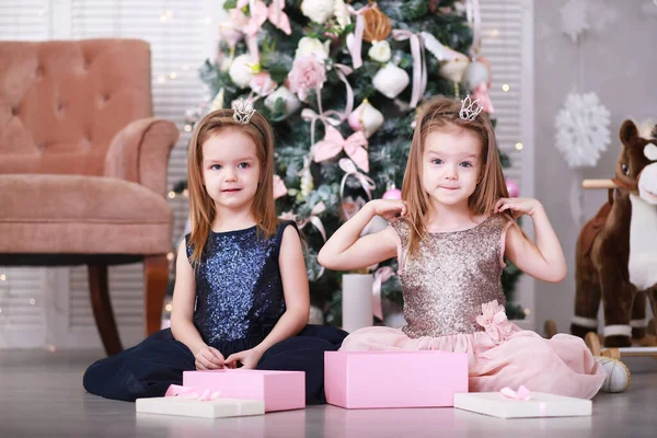 快乐的姐妹们在家里聚会庆祝圣诞节 有孩子的圣诞家庭打开圣诞礼物 圣诞树 图库照片