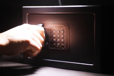 Parayla çelik kasa. Otel odasındaki güvenli para kutusuna el koyarak.