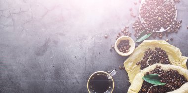 Bir poşet kahve. Kahve çekirdekleri masada kavrulmuş. Pişirmek için yapraklı kahve çekirdekleri.