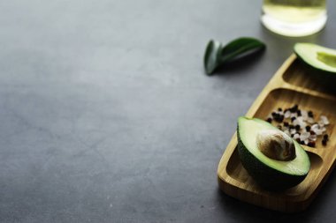 Avokado yemek tarifleri. Tahta kesme tahtasında servis edilen olgun yeşil avokado..