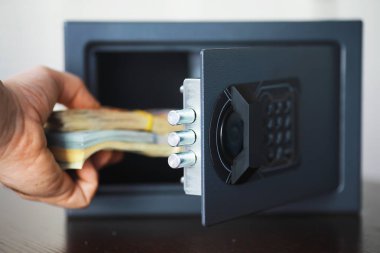Parayla çelik kasa. Otel odasındaki güvenli para kutusuna el koyarak.