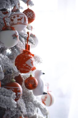 Noel tatili geçmişi. Gümüş ve kırmızı mücevher ağaçta asılı, kar ve bokeh ile, kopyalama alanı.