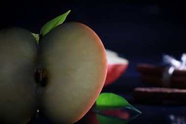 Siyah arka planda elma dilimleri olan kompozisyon. Siyah arka planda su damlaları olan bir dilim elma. Sofrada sulu elma.