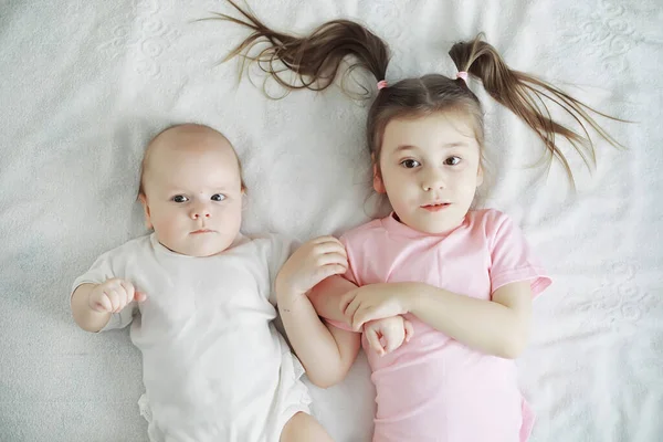 아이들은 갓난아기인 여동생 침대에 있습니다 어린이들의 — 스톡 사진