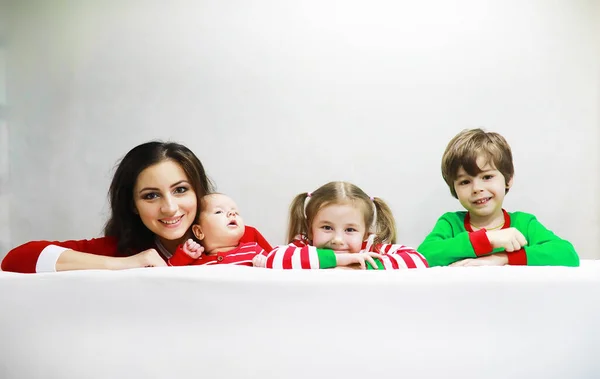 줄무늬 잠옷을 가족은 집에서 어린아이들이 소파에 현수막이 — 스톡 사진