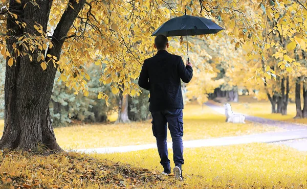 Gözlüklü Genç Bir Adam Yağmur Sırasında Elinde Şemsiyeyle Parkta Yürür — Stok fotoğraf