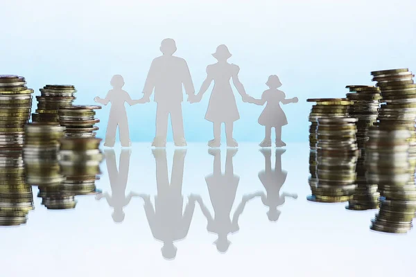 Silhouette of four people and stacks of money. Family concept. Family financial budget. Savings investment.