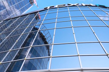 Ön cephenin mimari ayrıntıları diğer binaların ve güneşin birden fazla yansımasıyla birlikte. Modern binanın dış cephesi. Mimari soyut arkaplan