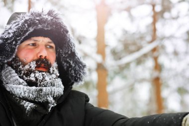 Palto ve İskoç kumaşlı yakışıklı bir adamın açık hava portresi. Sıradan kış modası.