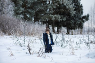 Mutlu bir aile kışın dışarıda karda oynar ve güler. Şehir parkı kış günü