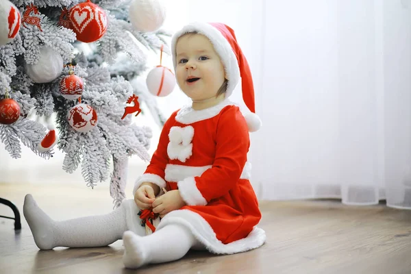 Merry bright christmas. Lovely baby enjoy christmas. Childhood memories. Santa girl little child celebrate christmas at home. Family holiday. Girl cute child cheerful mood play near christmas tree.