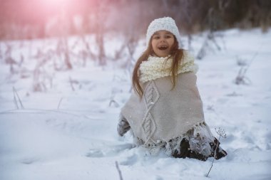 Mutlu bir aile kışın dışarıda karda oynar ve güler. Şehir parkı kış günü