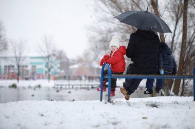 Kışın parktaki çocuklar sno ile oynarlar.