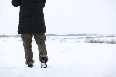 Kış ormanlarında sakallı adam. Çekici, mutlu, sakallı genç bir adam parkta yürüyor..