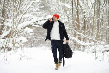Kışın ormanda bir adam. Sırt çantalı bir turist kışın ormana gider..