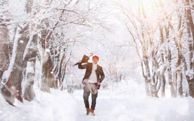 Parkta yürüyen bir adam. Kışın kar altında şemsiyeli genç bir adam..