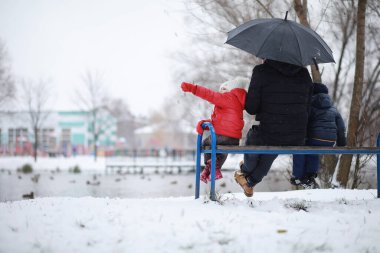 Kışın parktaki çocuklar sno ile oynarlar.