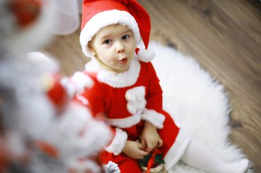 Mutlu noeller. Güzel bebek, Noel 'in tadını çıkar. Çocukluk anıları. Noel Baba kızı küçük çocuk Noel 'i evde kutluyor. Aile tatili. Tatlı kız, neşeli çocuk, Noel ağacının yanında oyun oynuyor..